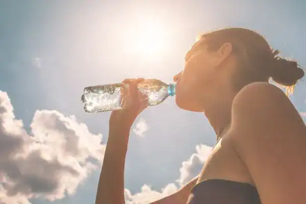 Hydration: The Secret Ingredient for a Toned Stomach and Enhanced Fitness 3 Image of woman drinking water to hydrate Northampton after run.