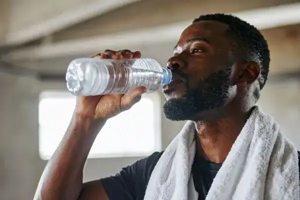 Hydration: The Secret Ingredient for a Toned Stomach and Enhanced Fitness 1 Image of man drinking water to improve hydration Northampton after work out.